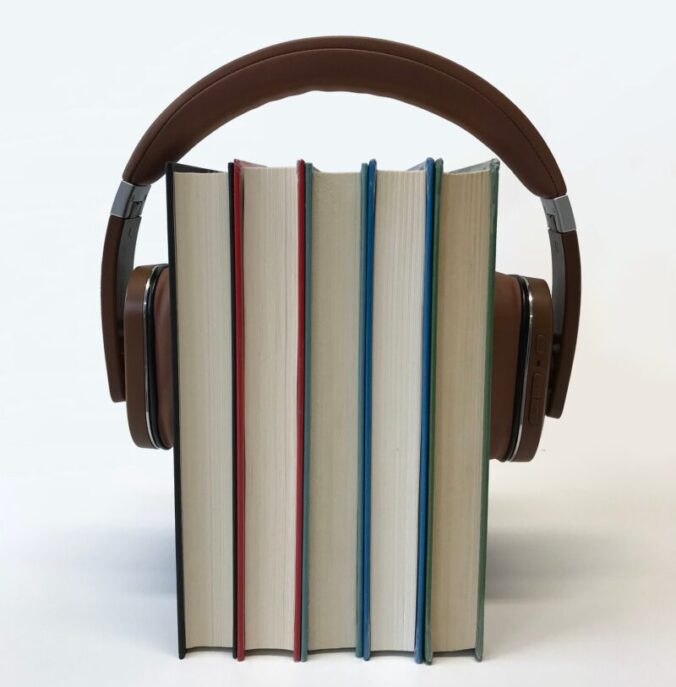 A stack of books with headphones around them