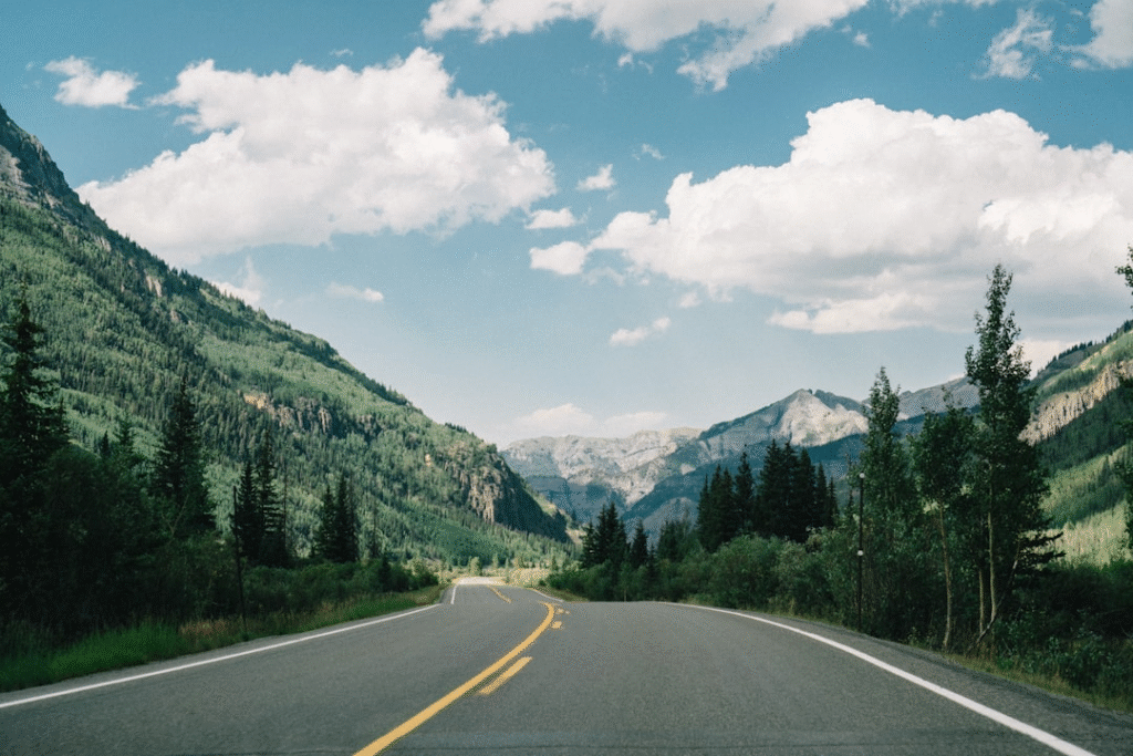 A long road leading into snow-capped mountains